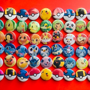 Peut inclure: Une collection de 42 boutons ronds de personnages Pokémon. Les boutons sont colorés et présentent divers personnages Pokémon, notamment Pikachu, Dracaufeu et Bulbizarre. Les boutons sont disposés en grille sur un fond rouge.