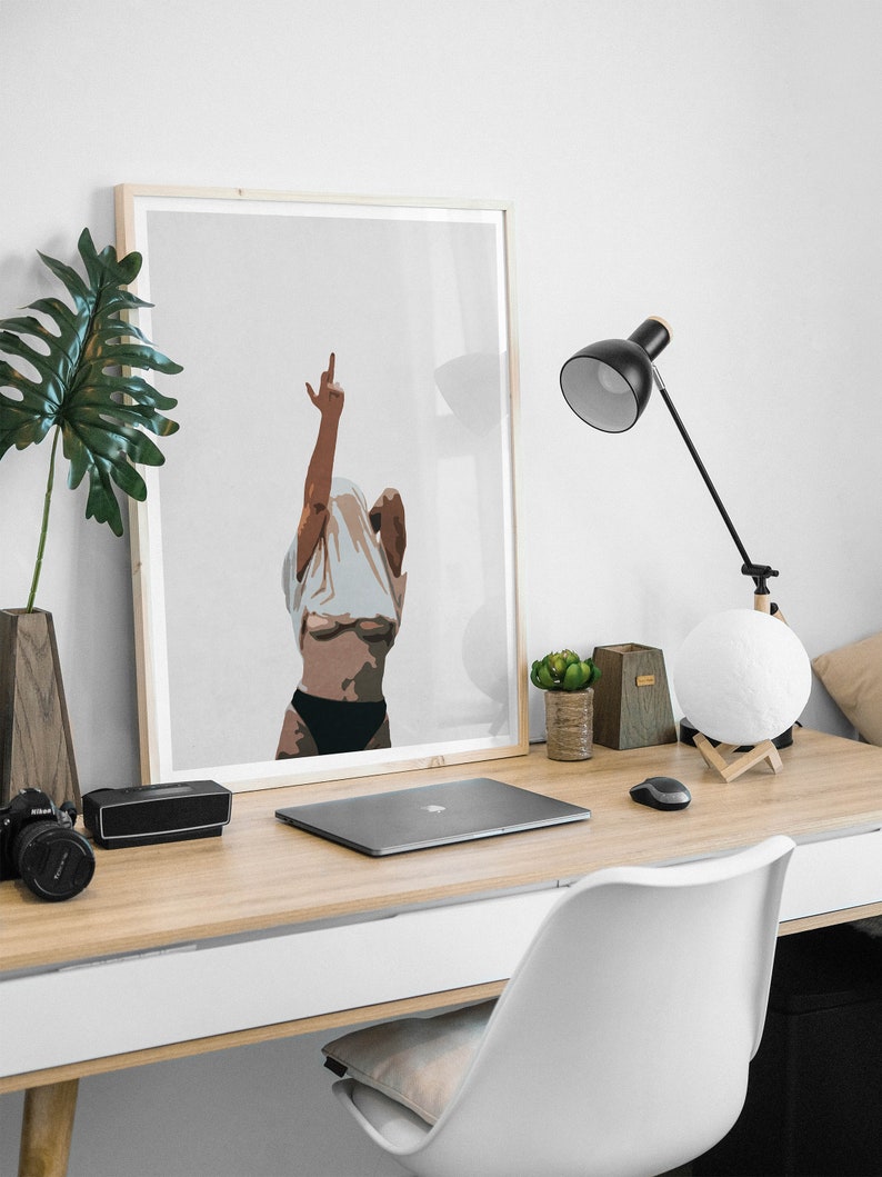 May include: A framed illustration of a person with their arm raised in the air, making a middle finger gesture. The person is wearing a white shirt and black underwear. The illustration is on a light gray background.