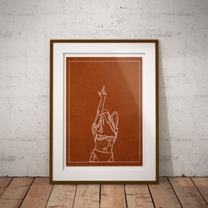 May include: A white line drawing of a person with their arm raised in the air, making a middle finger gesture. The drawing is on a brown background and framed in a white frame with a brown wood border.
