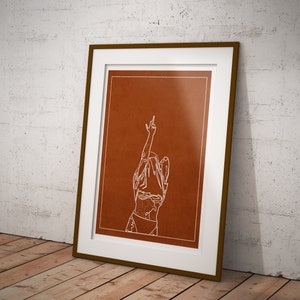 May include: A framed print with a brown background and a white line drawing of a person with their arm raised in the air, making a middle finger gesture.