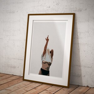 May include: A framed illustration of a person with their shirt pulled up, giving the middle finger. The background is a light gray.