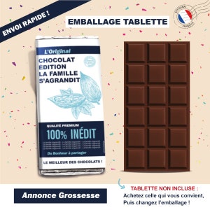 May include: A brown chocolate bar wrapper with the text "L'Original Chocolat Edition La Famille S'Agrandit" and "100% INEDIT" in blue and white. The wrapper features a cocoa pod illustration and the text "Qualit&eacute; Premium". The wrapper is next to a brown chocolate bar with 12 squares.