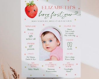 May include: A pink and green first birthday milestone poster with a strawberry illustration and a photo of a baby girl. The poster includes the baby's name, Elizabeth, and details about her first year, including her nickname, height, weight, favorite song, food, and book.