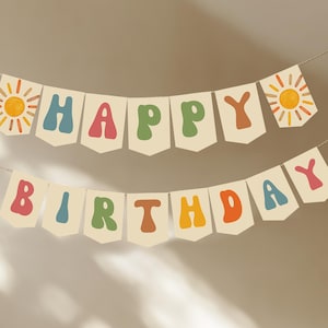 May include: A banner with the words "HAPPY BIRTHDAY" in colorful, retro-style letters. The banner is cream-colored with a sun graphic on each end. The letters are in shades of blue, pink, green, orange, and brown.