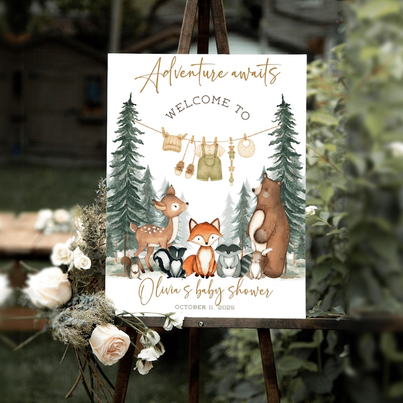May include: A baby shower sign with the text "Adventure awaits" and "Welcome to". The sign features watercolor illustrations of woodland animals, baby clothes, and the text "Olivia's baby shower" and the date.
