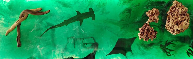 May include: An abstract art piece featuring marine life and organic shapes. The artwork includes a hammerhead shark, stingrays, and coral-like formations in shades of brown and gold, set against a green, watery background.
