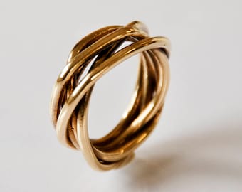 May include: A gold-toned ring made of multiple intertwined bands.