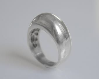 May include: A silver ring with a smooth, rounded, and slightly domed top.