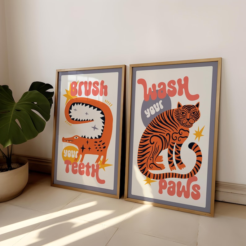 K&ouml;nnte beinhalten: Zwei gerahmte Drucke mit bunten Illustrationen und Text. Der linke Druck zeigt ein rotes Alligator mit dem Text "Putze deine Z&auml;hne". Der rechte Druck zeigt einen orangefarbenen Tiger mit dem Text "Wasche deine Pfoten".