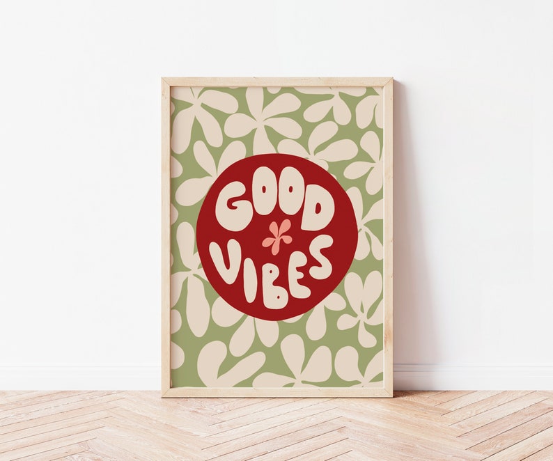 May include: A framed print with a green and white floral pattern background. A red circle with the text "GOOD VIBES" in white is in the center of the print.