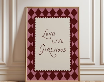 May include: Framed art print with the words "Long Live Girlhood" in a cursive font. The print has a cream-colored background with a burgundy border and a diamond pattern. The frame is a light brown color.