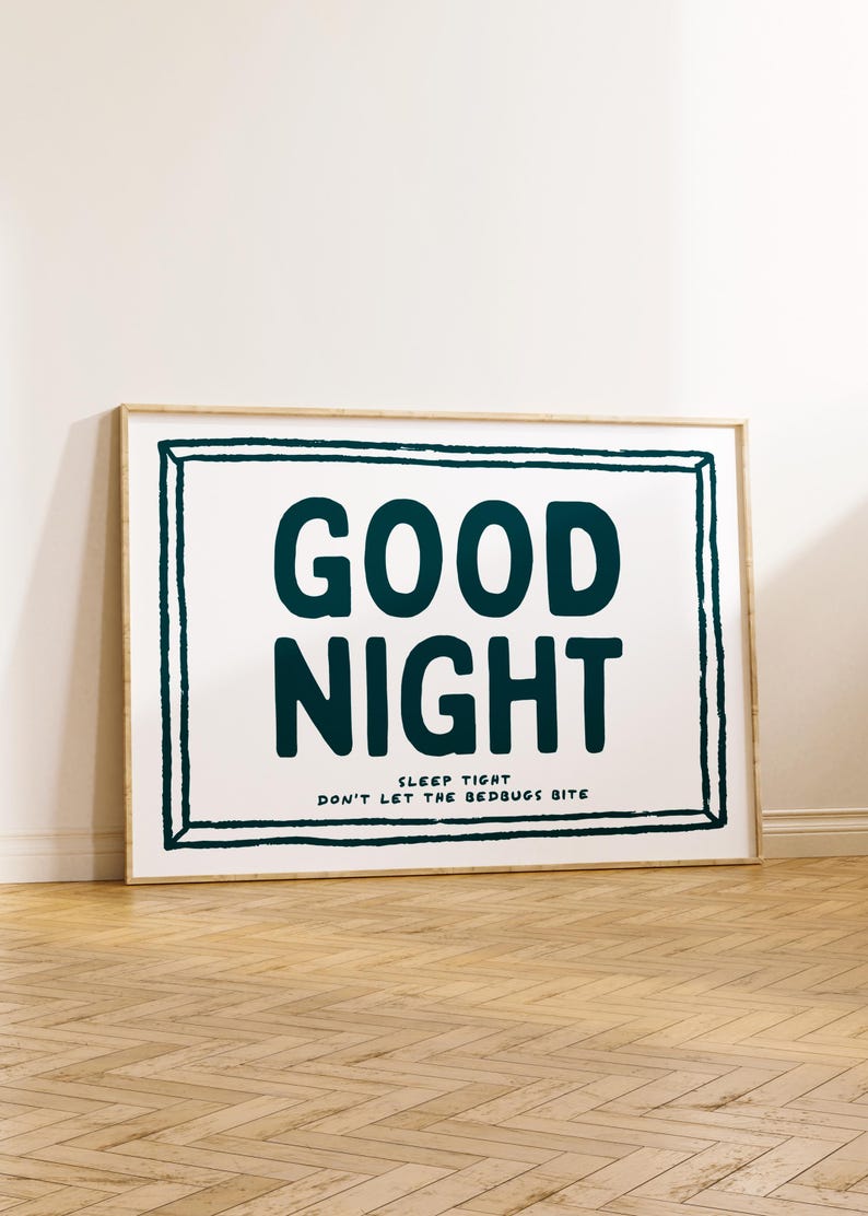 May include: A framed print with a white background and a black frame. The print features the text "GOOD NIGHT" in large, bold, dark blue letters. Below the text is the phrase "SLEEP TIGHT DON'T LET THE BEDBUGS BITE" in smaller, dark blue letters.