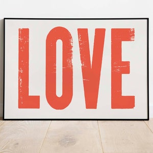 May include: A framed print with the word "LOVE" in large, bold, red letters with a distressed, vintage look.