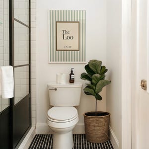 Personalised “The Loo” bathroom sign with sage green stripes displayed above a toilet in a modern powder room