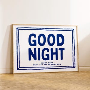 May include: A framed print with a white background and a blue inscription that reads "GOOD NIGHT SLEEP TIGHT DON'T LET THE BEDBUGS BITE".