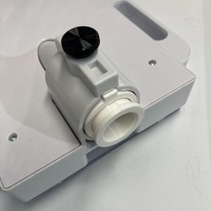 May include: A white plastic device with a black knob and a cylindrical component. The device has a handle and several screws. The cylindrical component has a white interior and a flared opening.