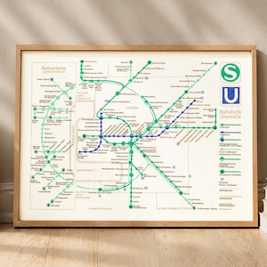 Könnte beinhalten: Eine gerahmte Karte eines öffentlichen Verkehrsnetzes mit grünen und blauen Linien, die Routen darstellen. Die Karte befindet sich in einem Holzrahmen und lehnt an einer Wand. Bücher sind auf dem Boden gestapelt.
