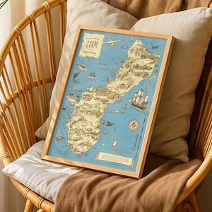 May include: A framed map of Guam with a vintage style. The map is in a wooden frame and features illustrations of landmarks, ships, and an airplane. The map is resting on a wicker chair with pillows and a brown blanket.