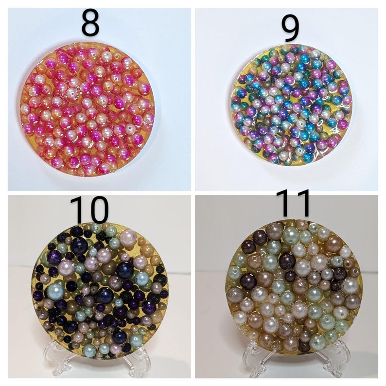 May include: Four decorative coasters with a gold rim and filled with small, colorful beads. The coasters are numbered 8, 9, 10, and 11. Coaster 8 has pink and white beads, 9 has blue and purple beads, 10 has dark blue and purple beads, and 11 has brown and green beads.