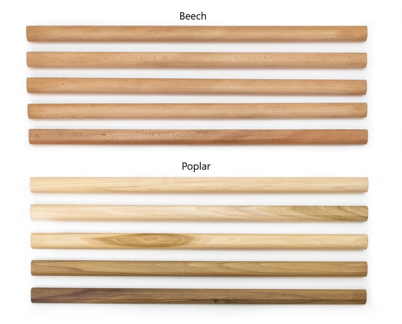 May include: Close-up of wooden dowels in two different wood types: beech and poplar. The beech dowels are a light brown color, while the poplar dowels are a lighter, more yellowish brown.