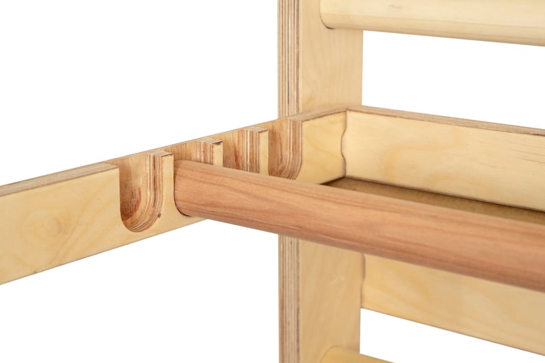 May include: Close-up of a wooden wall-mounted towel rack with a wooden dowel rod. The rack has multiple slots for hanging towels.