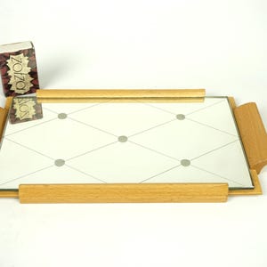 May include: A rectangular mirrored tray with wooden handles and trim. The mirrored surface has a diamond pattern with gray dots at the intersections. A small box of matches with the text "ZOZO" is on the tray.
