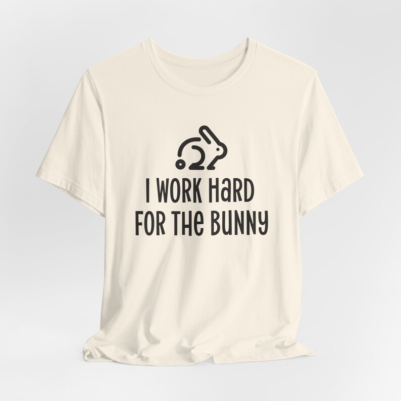 Natural color graphic t-shirt with rabbit design that says I Work Hard For The Bunny.