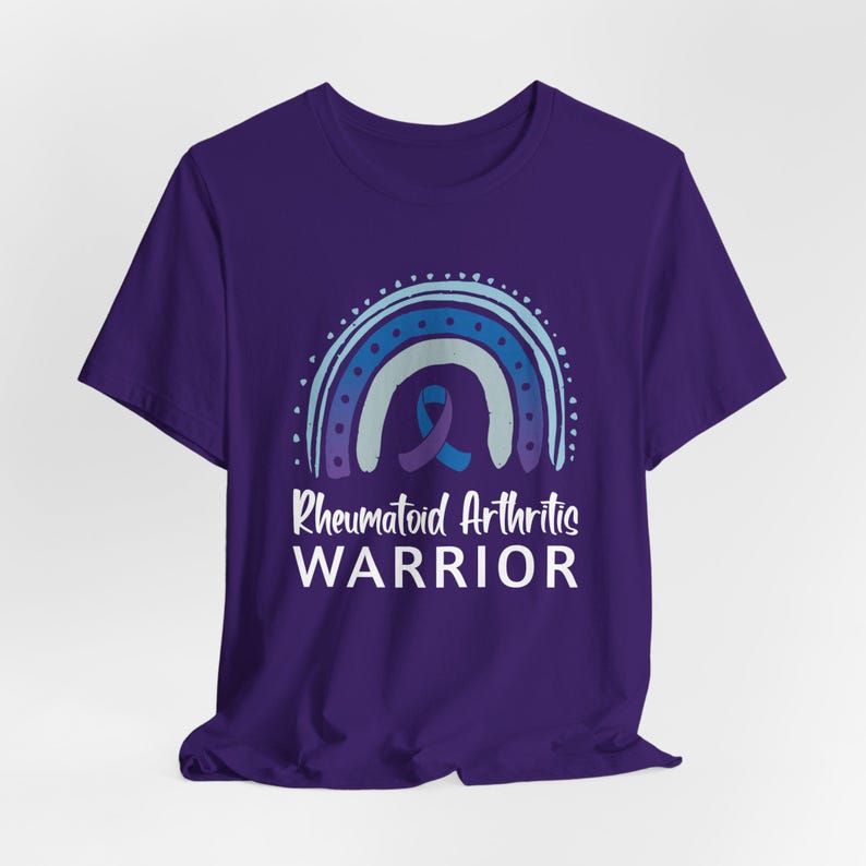 Purple graphic t-shirt with blue and purple rainbow and ribbon that says Rheumatoid Arthritis Warrior