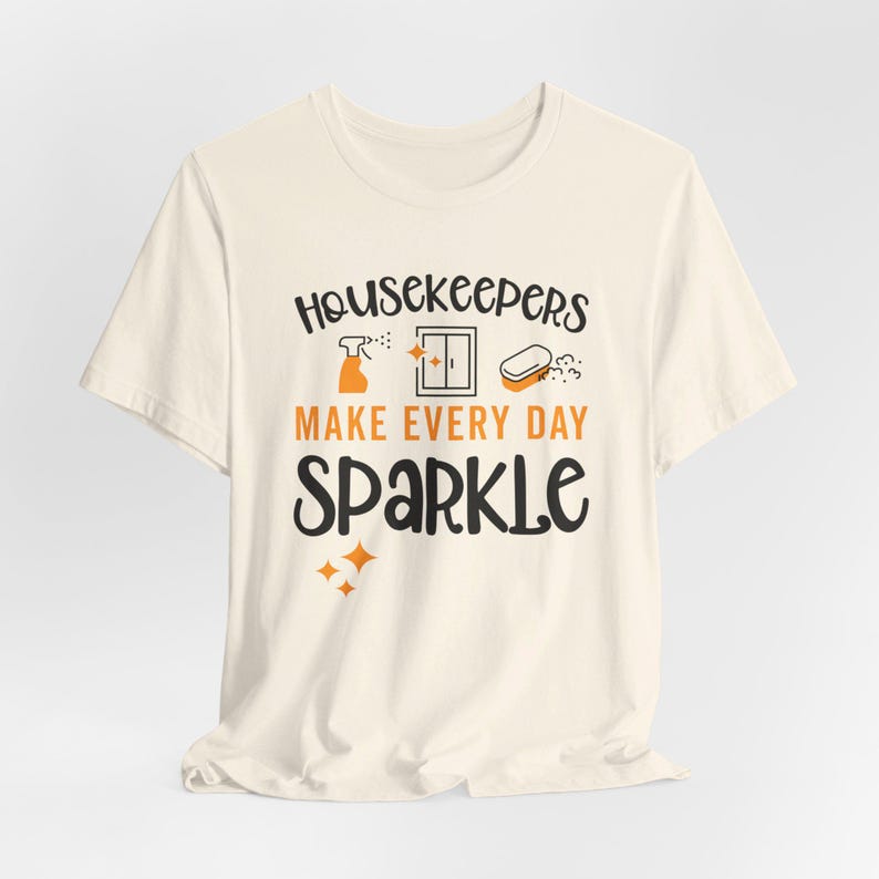Natural colored graphic t-shirt with cleaning icons that says Housekeepers Make Every Day Sparkle
