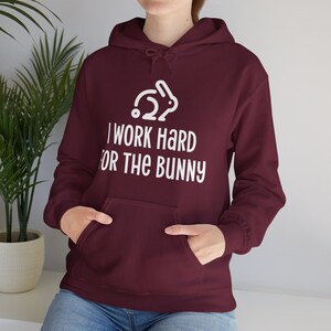 Maroon hoodie with rabbit design that says I Work Hard For The Bunny.