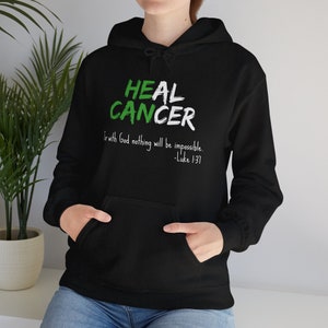Black hoodie that says He Can Heal Cancer - For With God Nothing Will Be Impossible - Luke 1:37. The design is in green and white.
