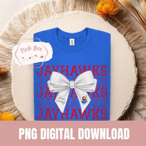 May include: A royal blue t-shirt with the word "JAYHAWKS" repeated in red. A white bow is placed over the text. The words "Kansas University" and a Jayhawk logo are on the bow. The words "PNG DIGITAL DOWNLOAD" are at the bottom.
