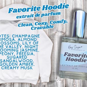 May include: A white hoodie with the text "Favorite Hoodie" and fragrance notes listed in blue. A perfume bottle with the same name and a silver cap is also shown. The bottle contains 15 mL of perfume.