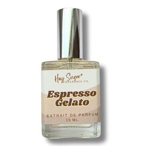 May include: A clear glass perfume bottle with a silver cap. The label reads "Hey Sugar Fragrance Co." and "Espresso Gelato." The bottom of the label says "EXTRAIT DE PARFUM 15 ML."
