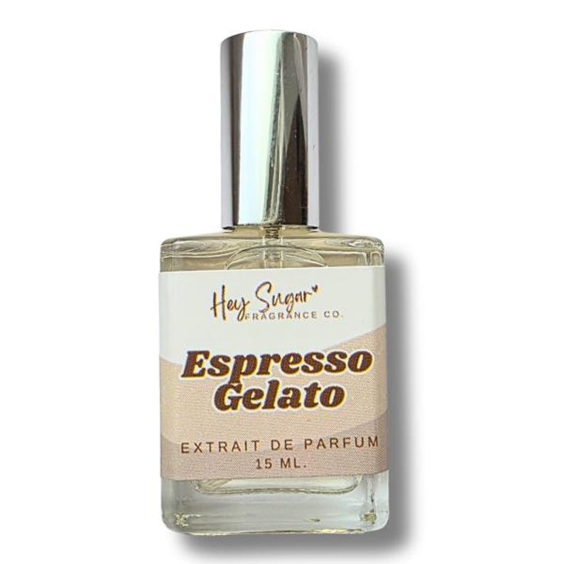 May include: A clear glass perfume bottle with a silver cap. The label reads "Hey Sugar Fragrance Co." and "Espresso Gelato." The bottom of the label says "EXTRAIT DE PARFUM 15 ML."
