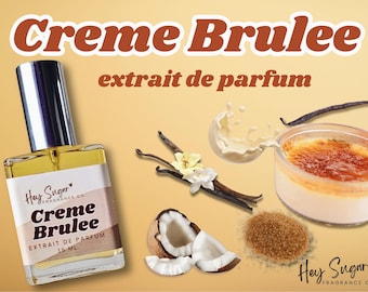 May include: A 15 ml bottle of Creme Brulee perfume by Hey Sugar Fragrance Co. The bottle is clear glass with a silver cap. The label is white with black text and a red heart. The perfume is inspired by the dessert Creme Brulee, and the image also includes vanilla beans, brown sugar, and coconut.