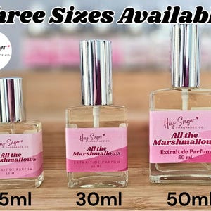 May include: Three clear glass perfume bottles with silver caps and pink labels that read "Hey Sugar" and "All the Marshmallows." Sizes are 15ml, 30ml, and 50ml. The text "Three Sizes Available!" is at the top.