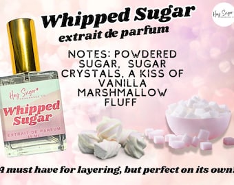 May include: A perfume bottle labeled "Whipped Sugar" with a gold cap, next to marshmallows and sugar cubes. The label lists notes of powdered sugar, sugar crystals, vanilla, and marshmallow fluff. The text "extrait de parfum" is also visible.