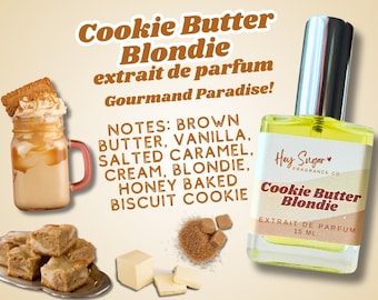 May include: A 15 ml bottle of Cookie Butter Blondie extrait de parfum by Hey Sugar Fragrance Co. The bottle is clear glass with a yellow liquid inside. The label is white with brown text and a red heart. The notes are brown butter, vanilla, salted caramel, cream, blondie, honey baked biscuit cookie.