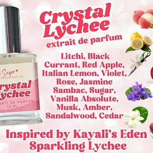 May include: A clear glass bottle with a silver cap and a pink label that reads "Hey Sugar Fragrance Co. Crystal Lychee Extrait de Parfum 15 ML". The bottle is surrounded by a pink background with the text "Crystal Lychee extrait de parfum" in large white letters. Below the bottle is the text "Inspired by Kayali's Eden Sparkling Lychee". The image also includes various fruits and flowers, including lychee, black currant, red apple, Italian lemon, violet, rose, jasmine, vanilla, musk, amber, sandalwood, and cedar.