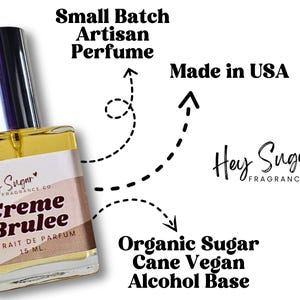 May include: A small glass bottle of Creme Brulee perfume by Hey Sugar Fragrance Co. The bottle is clear and has a gold cap. The label is white with black text and a pink heart. The text on the label reads "Hey Sugar Fragrance Co. Creme Brulee Extrait de Parfum 15 ML."