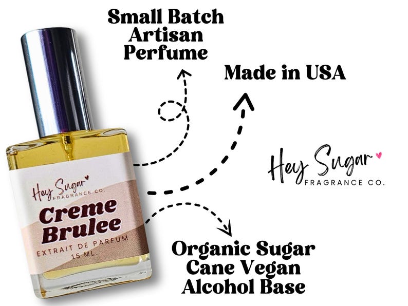 May include: A small glass bottle of Creme Brulee perfume by Hey Sugar Fragrance Co. The bottle is clear and has a gold cap. The label is white with black text and a pink heart. The text on the label reads "Hey Sugar Fragrance Co. Creme Brulee Extrait de Parfum 15 ML."