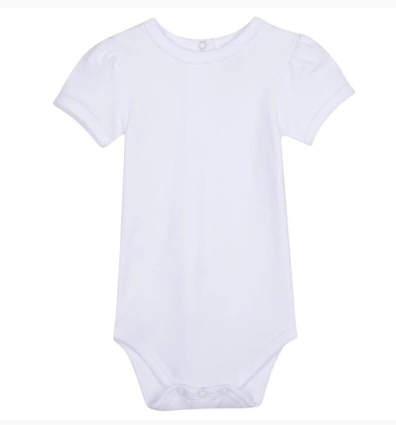 May include: White short-sleeved bodysuit with a round neckline and puffed sleeves.