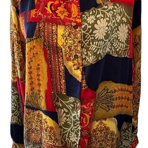 May include: A long-sleeved button-up shirt with a patchwork design. The shirt is made of a silky fabric and features a variety of colors, including red, yellow, green, and blue. The pattern is a mix of floral and geometric designs.