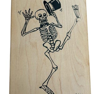 May include: A black and white rubber stamp of a skeleton wearing a top hat and bow tie, with the number 2400 printed on the bottom right corner.