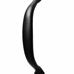 May include: A matte black metal cabinet handle with a curved, ergonomic shape. The handle features two circular mounting ends, each secured with a single black Phillips head screw, providing a clean and functional design for doors or drawers.