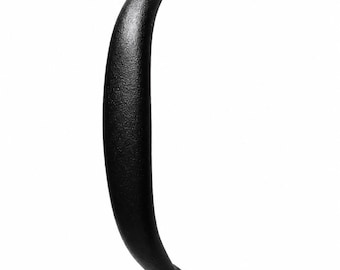 Peut inclure: Une poignée de meuble en métal noir mat avec une forme incurvée et ergonomique. La poignée présente deux extrémités de montage circulaires, chacune fixée par une vis cruciforme noire, offrant un design épuré et fonctionnel pour portes ou tiroirs.