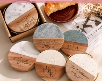 May include: A set of round coasters featuring a split design of natural wood and stone. Each coaster is engraved with custom text, including names like The Wilsons, Jancie and Aaron, and The Williams, alongside floral or monogram motifs.