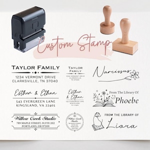 Könnte beinhalten: Ein schwarzer selbstfärbender Stempel und zwei Holzstempel sind über verschiedenen schwarzen Adress- und Bibliotheksstempelabdrücken abgebildet, darunter Texte wie Taylor Family, Esther & Ethan, Willow Creek Studio, Narcissus, Phoebe und Liora.