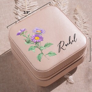 a pink suitcase with a purple flower painted on it
